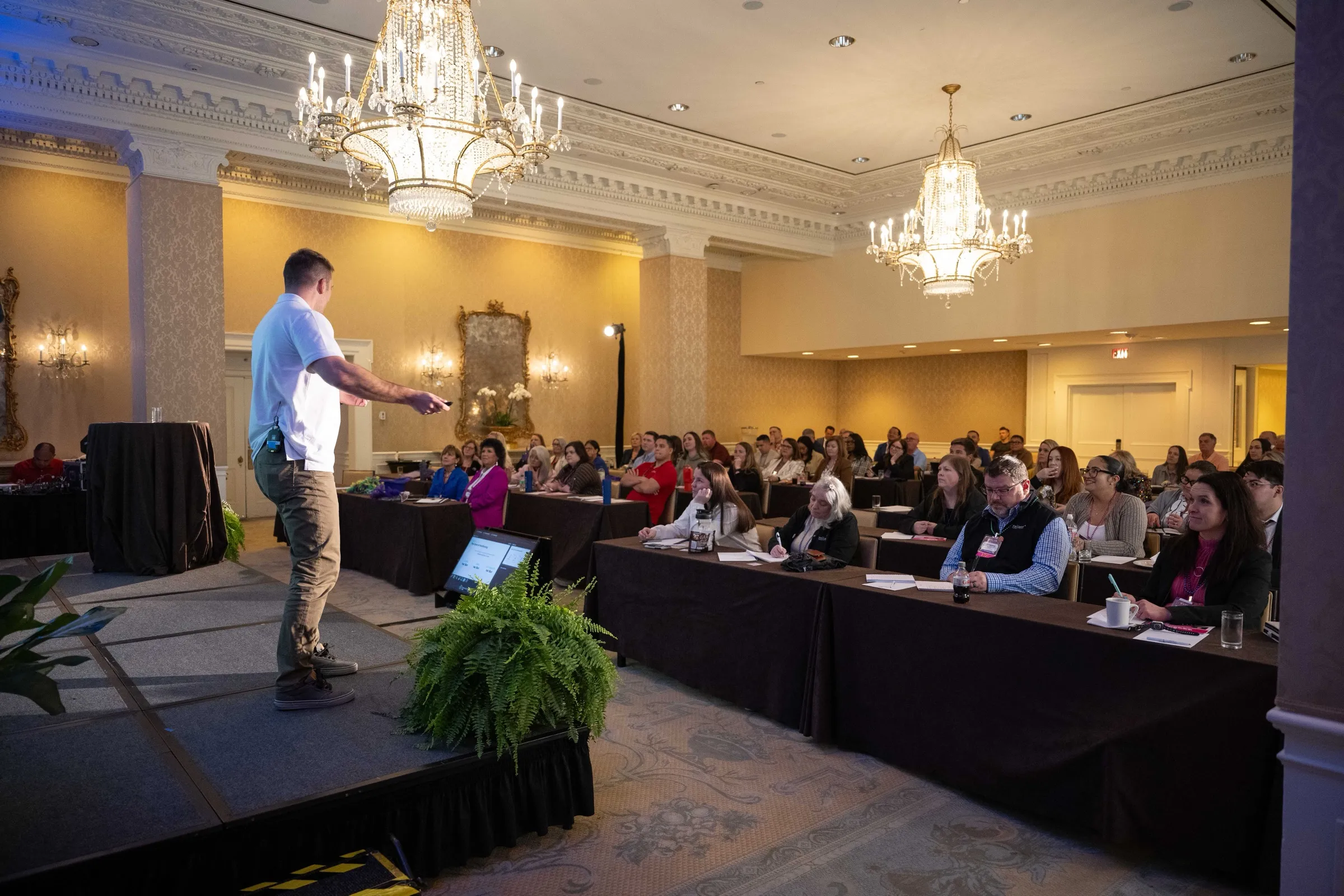 Chris DuBois presenting from the stage to a seated conference audience at FSI's Evolve